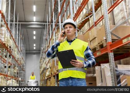 logistic business, technology and shipment concept - businessman calling on smartphone at warehouse. businessman calling on smartphone at warehouse. businessman calling on smartphone at warehouse