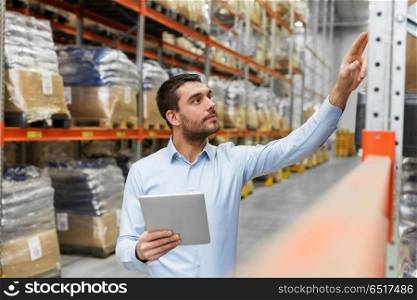 logistic business, technology and shipment concept - businessman with tablet pc computer checking goods at warehouse. businessman with tablet pc at warehouse. businessman with tablet pc at warehouse