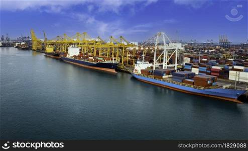 Logistic container ship from sea port warehouse with working crane bridge for delivery containers shipment. for transport or import export to global logistics concept. blue sky background