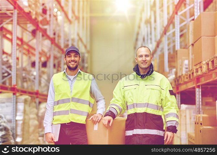 logistic, delivery, shipment, people and export concept - happy men or manual workers with boxes at warehouse