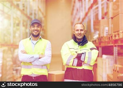 logistic, delivery, shipment, people and export concept - men or manual workers with boxes at warehouse