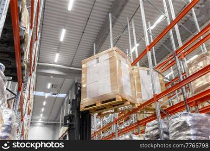 logistic, storage, shipment and industry concept - forklift loader loading cargo to warehouse shelves. forklift loader loading cargo to warehouse shelves