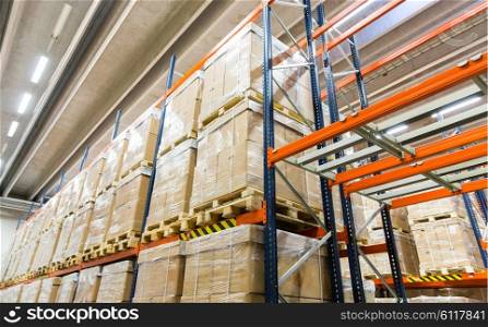 logistic, storage, shipment, industry and manufacturing concept - cargo boxes storing at warehouse shelves