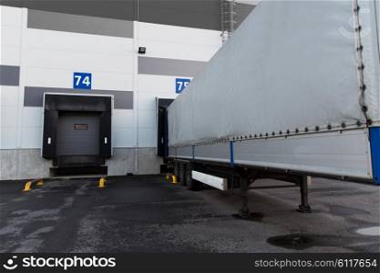 logistic, storage, shipment, transportation and loading concept - warehouse gates and truck loading