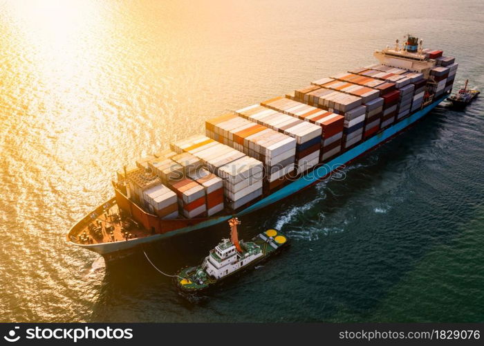 Logistics and transportation of International Container Cargo ship in the ocean and over the sunset background aerial view from drone