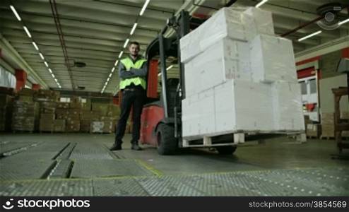 Logistics business and shipping facility, portrait of manual worker operating forklift to move boxes and parcels, man at work in warehouse, worker in industry. 5of19