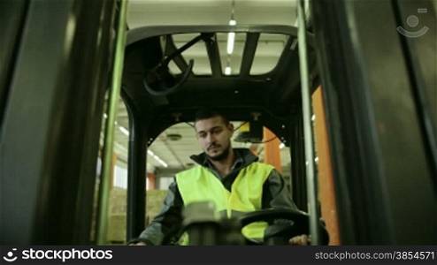 Logistics business and shipping facility with manual worker operating fork lift to move boxes and parcels, man at work in warehouse, worker in industry. 8of19