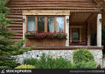 logs N?ottage. Window with flowers in logs chalet