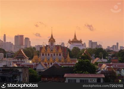 Loha Prasat Wat Ratchanatda and Golden Mountain pagoda, a buddhist temple or Wat Saket with skyscraper buildings in Bangkok Downtown, urban city at sunset, Thailand. Thai Landmark. Architecture.