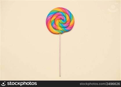 Lollipop swirl on wooden stick on beige paper background
