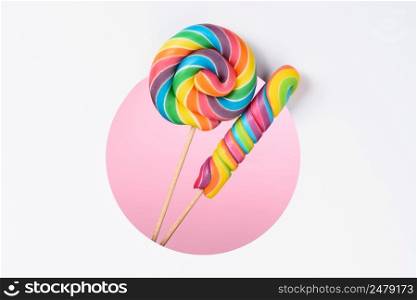 Lollipops candy colorful rainbow in a layered paper design with circle cut hole pink background and copy space
