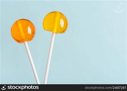 Lollipops on white sticks on blue pastel background with copy space