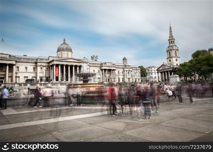 LONDON - AUGUST 10, 2019: Groups of tourists and locals enjoy the sunshine at the main entrance to the National Gallery in Trafalgar Square. The gallery houses the national collection of western European painting. Long exposure.