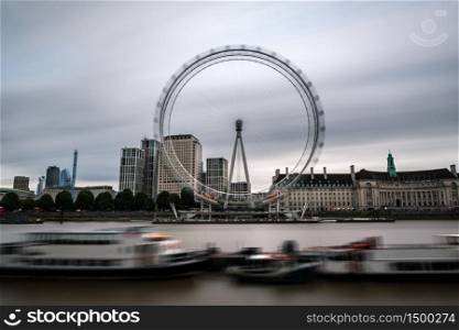 London cityscape by the river Thames with the Millennium Wheel on a grey rainy Summer day. Long exposure.