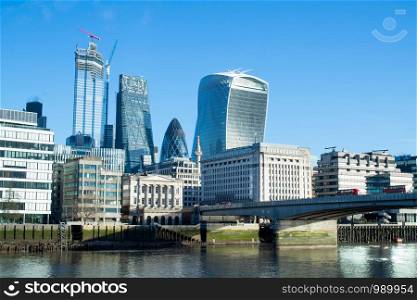 London Financial Skyline With River Thames And London Bridge In Foreground