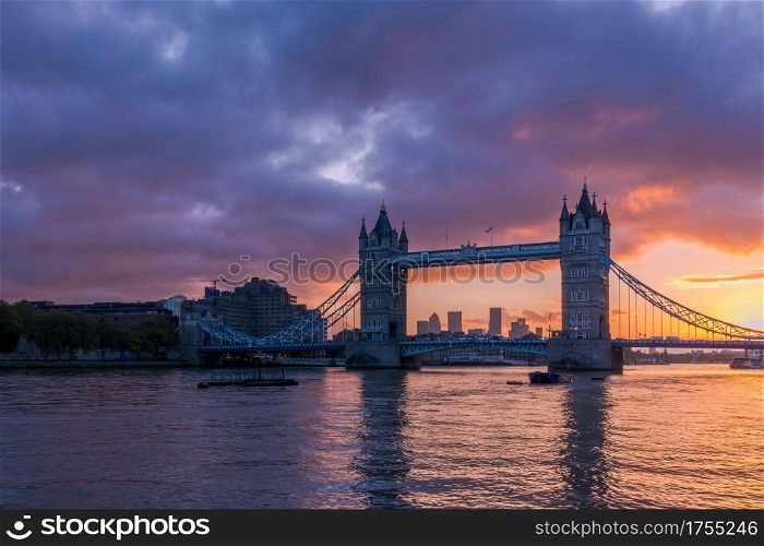 London&rsquo;s Tower Bridge illuminated by a fiery sunrise, with Canary Wharf in the background