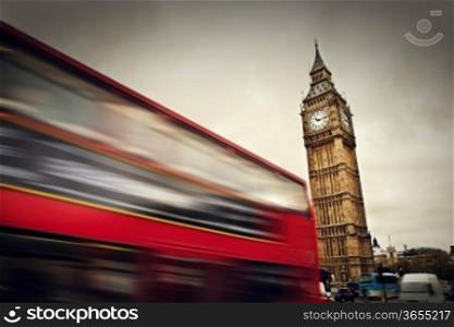 London, the UK. Red bus in motion and Big Ben, the Palace of Westminster.