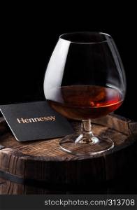 LONDON, UK - SEPTEMBER 04, 2018: Glass of Hennessy Cognac with original coaster on top of wood.