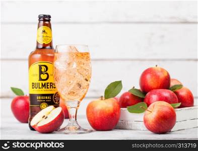 LONDON, UK - SEPTEMBER 13, 2018: Bottle of Bulmers Original Cider and glass of ice cubes with fresh apples on wood background.