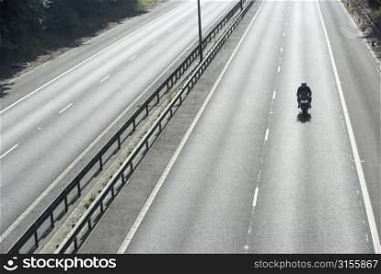 Lone Biker On An Empty Highway