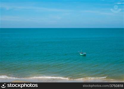 Lone fishing boat floating in blue sea, Vietnam