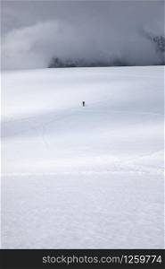 Lone hiker crosses white snow and ice landscape in Antarctica