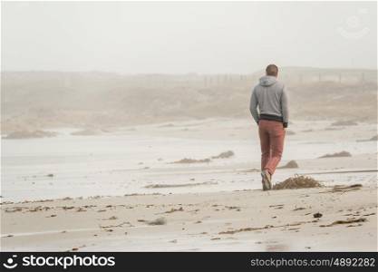 Lone man at beach, autumn. USA Pacific coast landscape, California