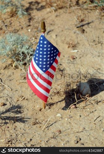 Lone US flag and its shadow in the desert.