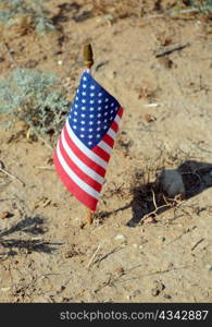 Lone US flag and its shadow in the desert.
