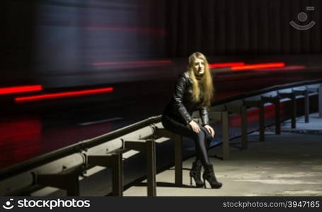 Loneliness concept. Young woman posing at highway at night