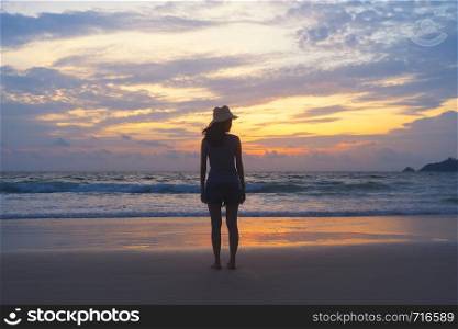 Lonely Asian woman thinking about problems and suffering at the beach during travel holidays vacation outdoors at ocean or nature sea at sunset time, Phuket, Thailand