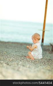 Lonely baby playing on beach