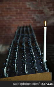 Lonely candle in a Italian Abbey. Concept of hope, faith, loneliness