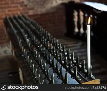 Lonely candle in a Italian Abbey. Concept of hope, faith, loneliness