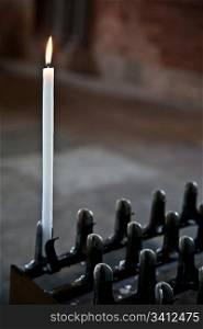 Lonely candle in a Italian Abbey. Concept of hope, faith, loneliness