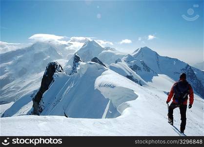 Lonely climber, on background the peaks and glaciers of Monte Rosa massif, west Alps, Europe