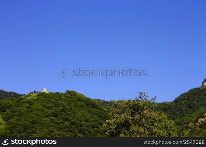 Lonely distant monastery on the top of mountain