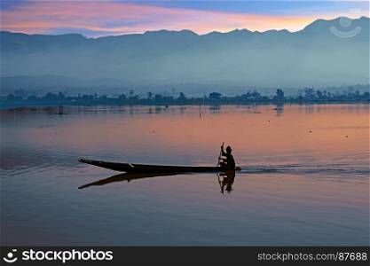 Lonely fisherman fishing at sunrise on a lake in Myanmar