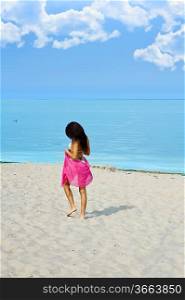 lonely girl walking on the beach near the sea with a red pareo