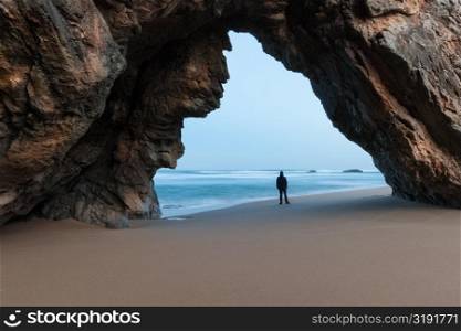 Lonely man under the rocky arch