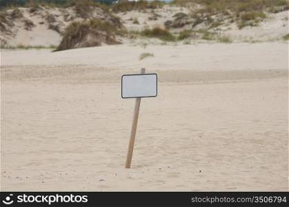 Lonely poster in the middle of the sand