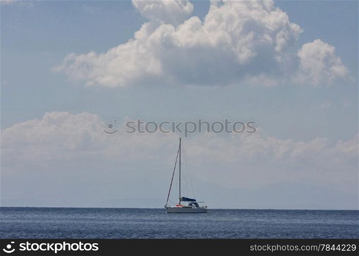 Lonely sailboat sails slowly expecting better wind
