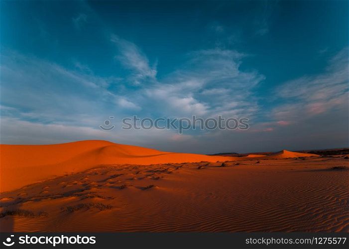 Lonely sand dunes under amazing evening sunset sky at drought desert landscape. Global warming concept