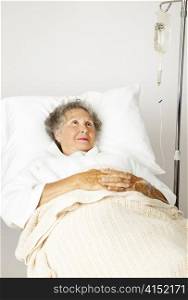 Lonely senior woman in the hospital bed, hooked up to an IV.