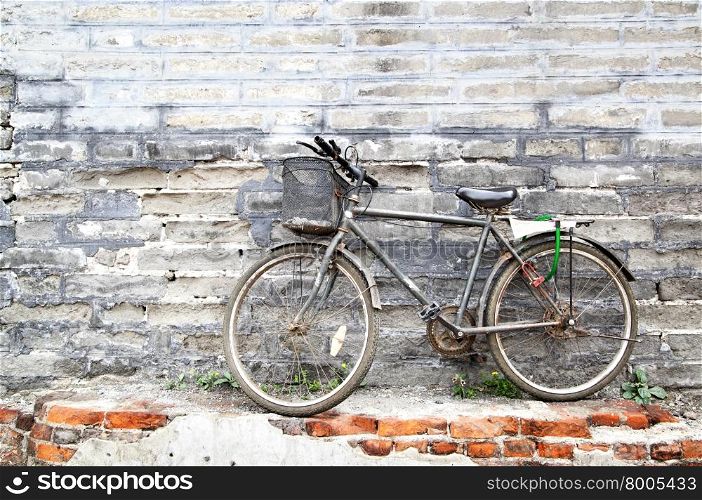 Lonely vintage bicycle near old brick wall