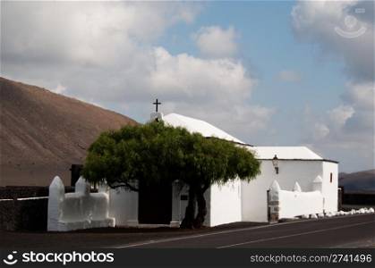 lonely white church in rough lava desert on lanzarote, canary islands, spain