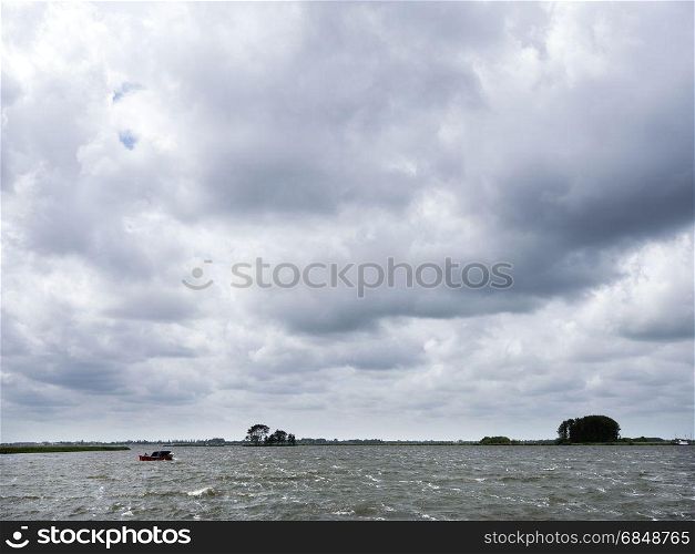lonely wooden vessel during summer storm on lake near sneek in dutch province of friesland in the netherlands