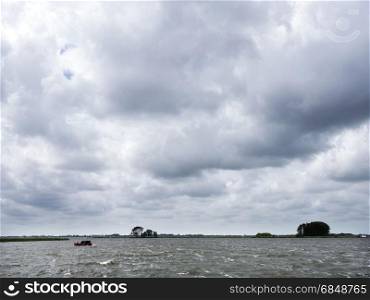 lonely wooden vessel during summer storm on lake near sneek in dutch province of friesland in the netherlands