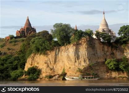 Long boat and brick stupas on the bank of river in Bagan, Myanmar