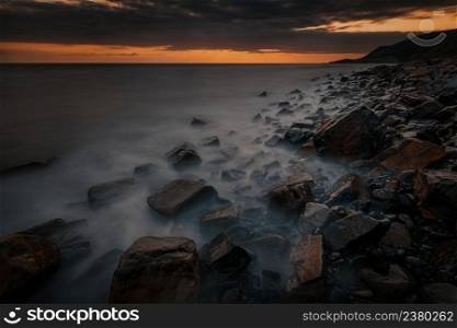 Long exposure dramatic sunset landscape with the rocky coast of Black sea